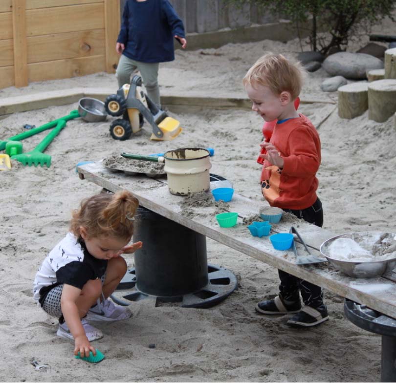 Toddlers playing in sand